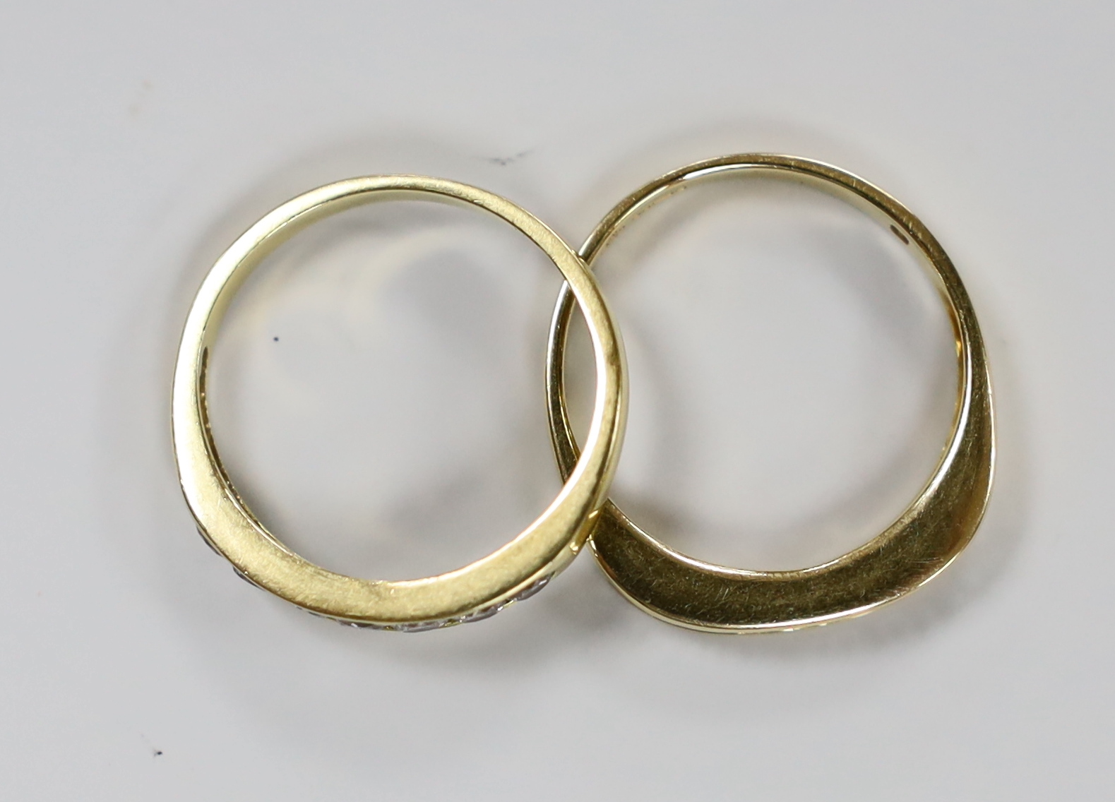 Two modern 18ct gold and channel set diamond half eternity rings, sizes P, gross weight 7.2 grams.